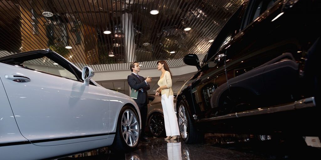 Salesman talking to woman in automobile workshops