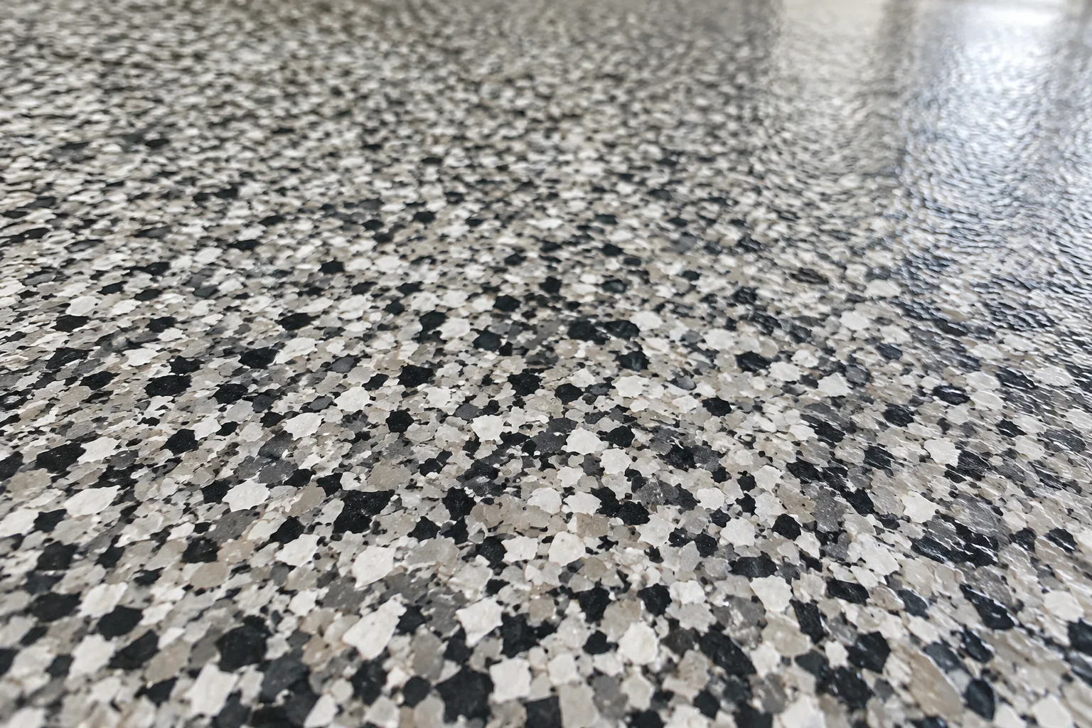 Close-up of charcoal, grey and white epoxy flooring flakes — illustration